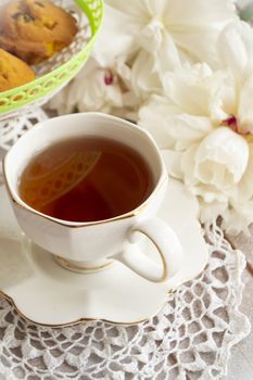 A tea party in the style of Shabby Chic. Delicate white peony white lace in retro style. On a white lace tablecloth. Vertical image