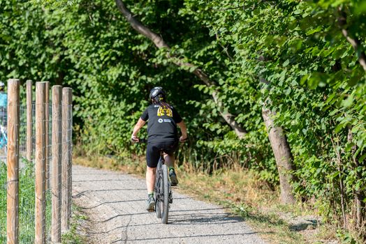 Ordino, Andorra: 26 August 2020: People riding bikes in the Valira del Orient river in Cami Ral in summer in Andorra.