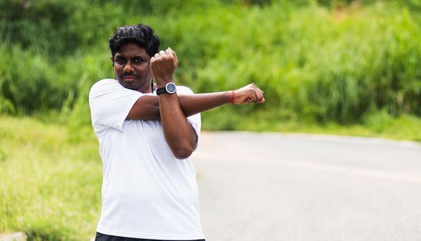 Close up Asian young sport runner black man wear watch he body warming up arms muscles before running at the outdoor street health park, healthy exercise Injury from workout concept