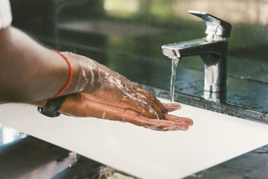 Closeup washing black man hands rubbing with soap and water in sinks to prevent outbreak coronavirus hygiene to stop spreading virus, hygiene for quarantine cleaning COVID-19 concept