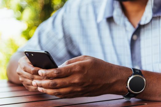 Happy Asian black businessman person holding a modern digital smart phone blank screen device technology and connecting networking online at the coffee cafe shop