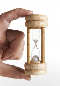 mans hand holding traditional egg timer against white background