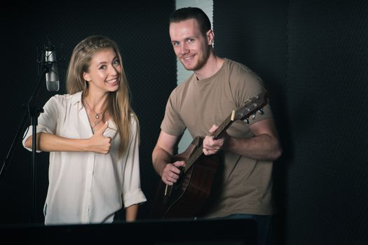 woman singer And man guitarist Caucasian people are practicing and Have fun laughing together in the sound recording studio. concept Artist audition for media, music, and performance produce