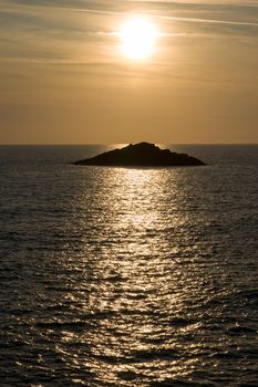 Ocean view with setting sun and sailboat on horizon, Quiberon, Brittany, France