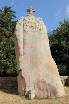 Menhir of Saint-Uzec. Menhir is about eight meters high and three meters wide. It is the largest menhir in France with Christian symbols. Pleumeur-Bodou, Brittany, France.