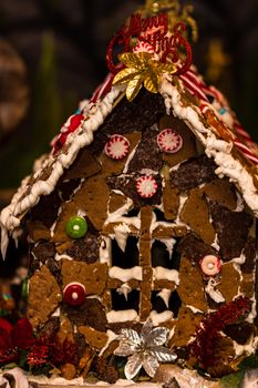 Colorful gingerbread house isolated on blurred background with Christmas decoration.