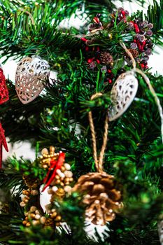 Christmas hanging decorations on fir tree. Decorated Christmas tree. Fir branch with Christmas baubles decorations.