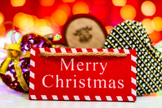 Merry Christmas text wooden sign, decorations and ornaments in a colorful Christmas composition.