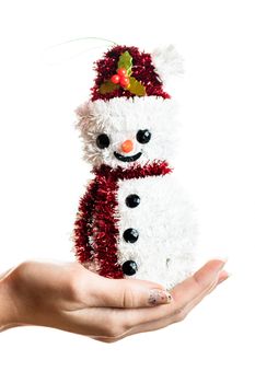 Hand holding Christmas snowman figurine isolated on white background