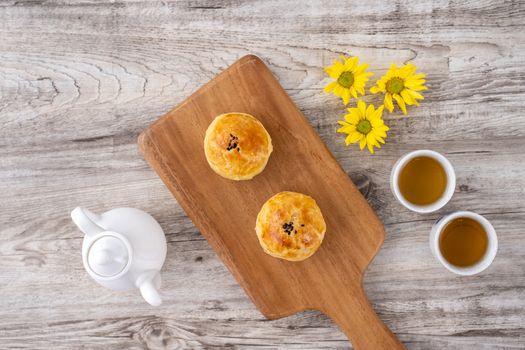 Moon cake yolk pastry, mooncake for Mid-Autumn Festival holiday, top view design concept on bright wooden table with copy space, flat lay, overhead shot