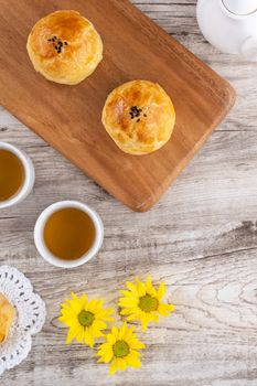 Moon cake yolk pastry, mooncake for Mid-Autumn Festival holiday, top view design concept on bright wooden table with copy space, flat lay, overhead shot