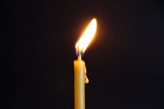 burning wax candle close up on dark background