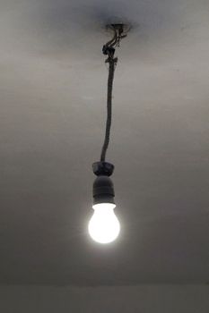 old included light bulb on the ceiling without lampshade.