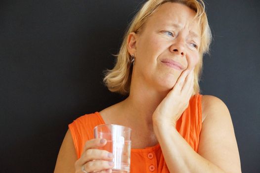 upset woman holding her bad tooth with her hand.