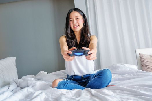 Beautiful girl playing video game on bed