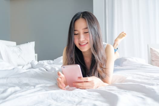 Young woman talking on the phone in bedroom at morning 