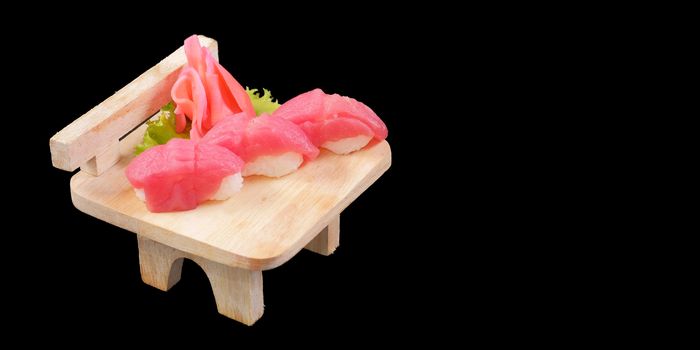 Japanese Cuisine - Salmon Sushi Roll on wood plate in blackbackground and space for text