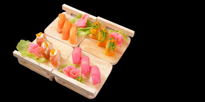 Japanese Cuisine - Sushi Roll on wood plate in black background and space for text