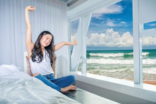 Woman stretch herself out after waking up in the morning on white background