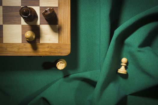 Wooden chess and chess board on green cloth