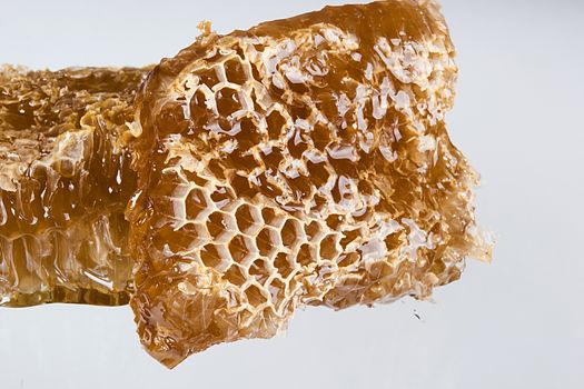 Pieces of honeycombs with organic honey on a white table