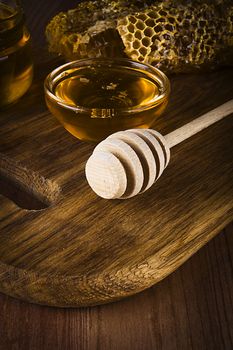 Yellow Honey and Honeycomb slice on a wooden table