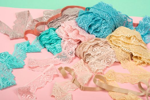 Abstract background with pile of color lace for Lingerie, panties, and bras on pink background. Delicate sophisticated glamorous elastic material. Using for Atelier and fabric store.