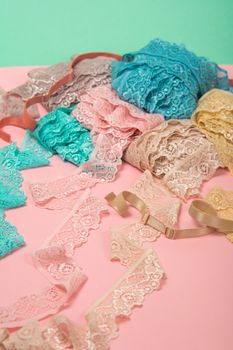 Abstract background with pile of color lace for Lingerie, panties, and bras on pink background. Delicate sophisticated glamorous elastic material. Using for Atelier and fabric store.