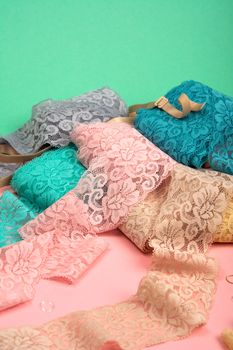 Abstract background with pile of color lace for Lingerie, panties, and bras on pink background. Delicate sophisticated glamorous elastic material. Using for Atelier and fabric store.