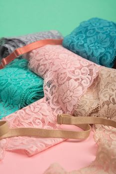 Abstract background with pile of color lace for Lingerie, panties, and bras on pink background. Delicate sophisticated glamorous elastic material. Using for Atelier and fabric store.