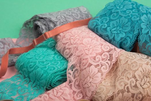 Abstract background with pile of color lace for Lingerie, panties, and bras on pink background. Delicate sophisticated glamorous elastic material. Using for Atelier and fabric store.