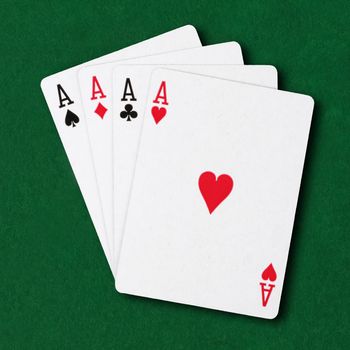 Four Aces on a green card table poker winning hand business concept