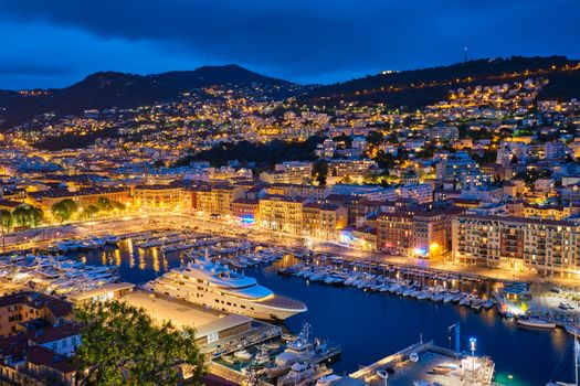 View of Old Port of Nice with luxury yacht boats from Castle Hill, France, Villefranche-sur-Mer, Nice, Cote d'Azur, French Riviera in the evening blue hour twilight illuminated