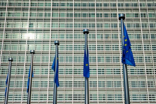 Helplessly drooping EU European Union flags with the European Comission building in Background. Brussles, Belgium