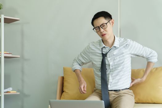 Young Asian man is sick From pain in the neck and back. A handsome businessman is tired and stressed by hard work. Online doctor consultation Distance with communication technology, connection concept