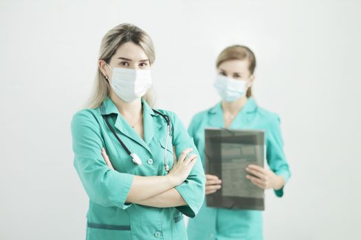 Two female doctor or nurse wearing medical masks looking at the camera. Stethoscope phonendoscope on the neck