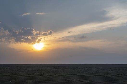 dark landscape of evening cloudy sunset on the background of an agricultural field