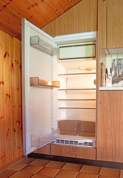 Old open fridge in a dated kitchen