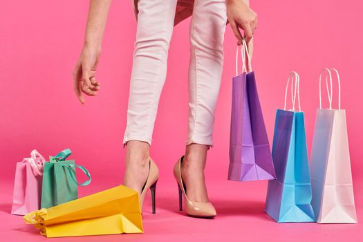 shopping bags female feet in shoes Shopaholic pink background. High quality photo