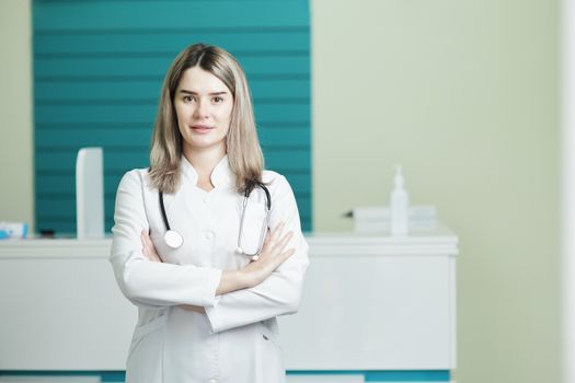 Female doctor or nurse in medical uniform, stethoscope on the neck. In the hospital reception