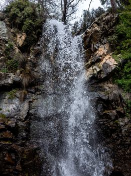 Waterfall on a mountain river in the hot summer in the mountains of Central Cyprus.