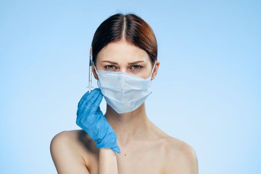 Woman in medical mask blue glove botox injection collagen rejuvenation. High quality photo