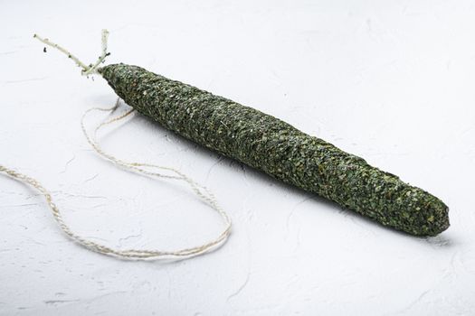 Fuet, salami wurst on white textured background.
