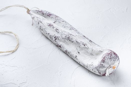 Longaniza spanish salami sausage on white textured background.
