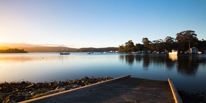 The idyllic setting across Wagonga Inlet at sunset in Narooma, NSW, Australia