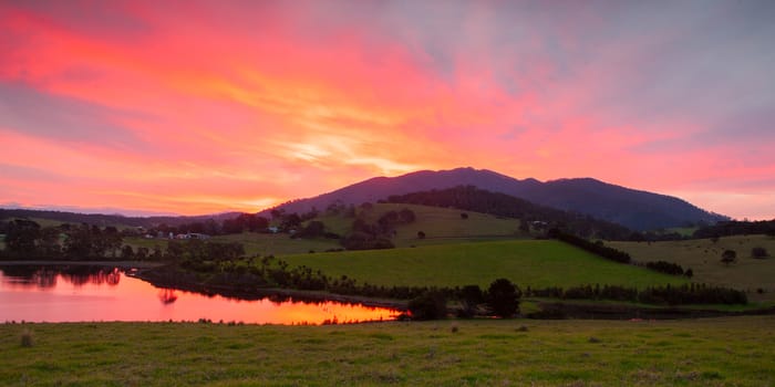 The idyllic setting across farmland at Mt Dromedary at sunset in Tilba, NSW, Australia
