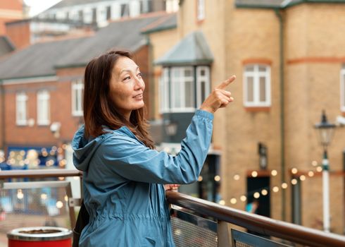 Asian woman in a blue coat walking around Europe city