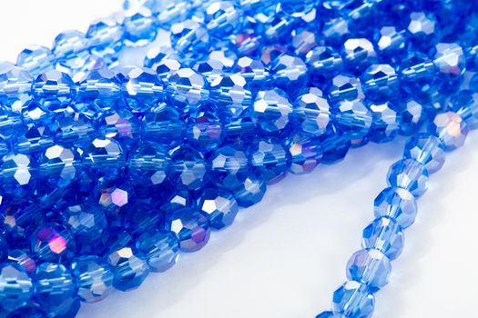 Beautiful blue Glass Sparkle Crystal Isoalted Beads on white background. Use for diy beaded jewelry. Space for text