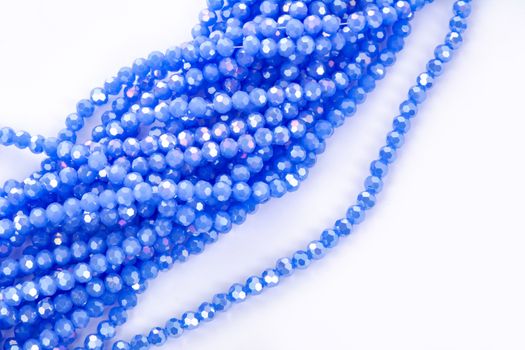 Beautiful blue Glass Sparkle Crystal Isoalted Beads on white background. Use for diy beaded jewelry. Space for text