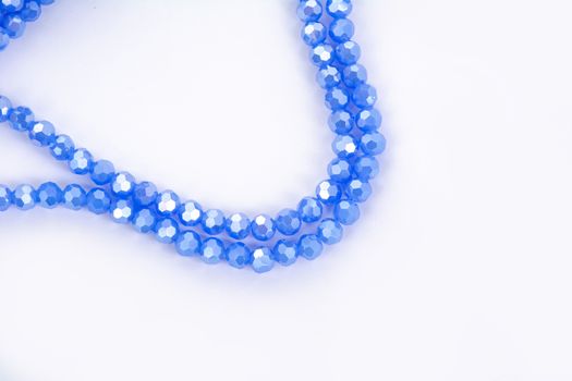 Beautiful blue Glass Sparkle Crystal Isoalted Beads on white background. Use for diy beaded jewelry. Space for text